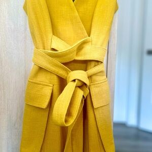 Golden yellow wrap dress. Snap closures. Belted waist.